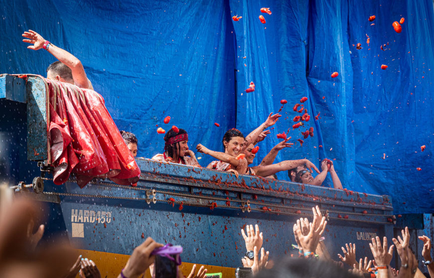 una ragazza lancia pomodori nel festival La tomatina in Spagna