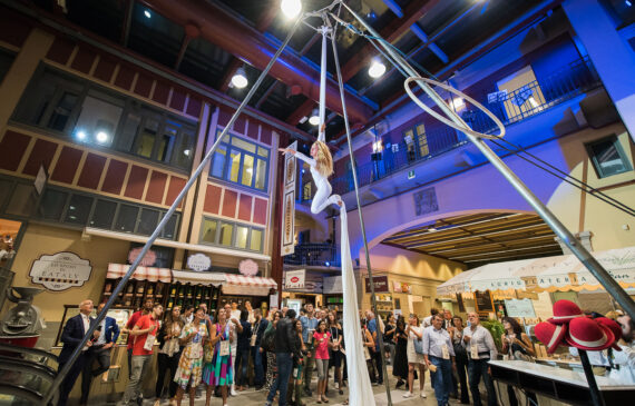 Una donna acrobata durante uno spettacolo con pubblico dentro Eataly a Torino