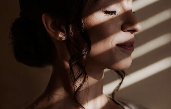 Primo piano di una sposa con la luce della tapparella che filtra sul viso