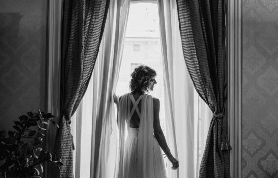 una sposa posa per una fotografia davanti ad una finestra nella sua abitazione in crocetta a Torino