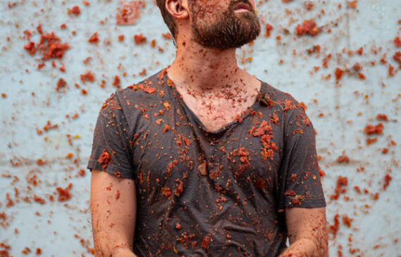 Ritratto di un uomo sporco di salsa di pomodoro durante l’evento la tomatina