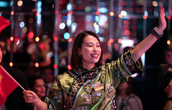 Una donna asiatica saluta il pubblico dal palco