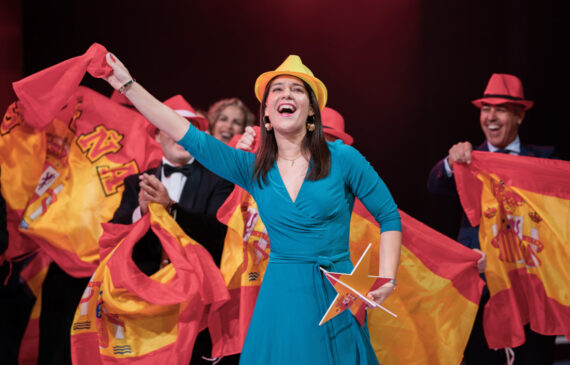 Una donna balla sul palco con una bandiera spagnola