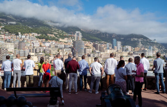 Una folla di persone osserva la città di Montecarlo da una balconata