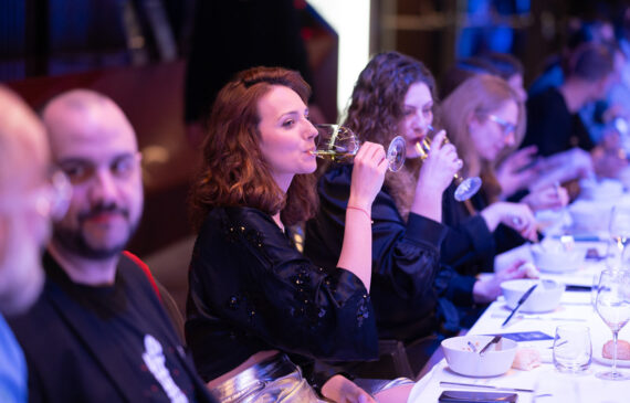 una donna beve durante una cena di gala