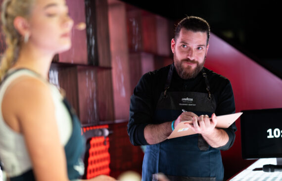 un giudice controlla l'esibizione di una partecipante al concorso barista challenge 2024