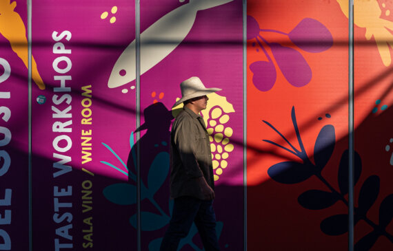 fotografo a torino un uomo che passa davanti ad un cartello colorato con il logo di TERRA MADRE