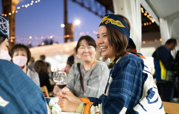 Una domma ride mentre brinda con amici durante l'evento terra madre a Torino