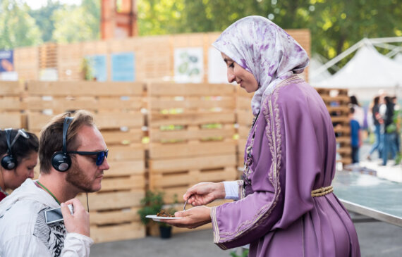 Una donna mostra a degli spettatori alcuni cibi tunisini