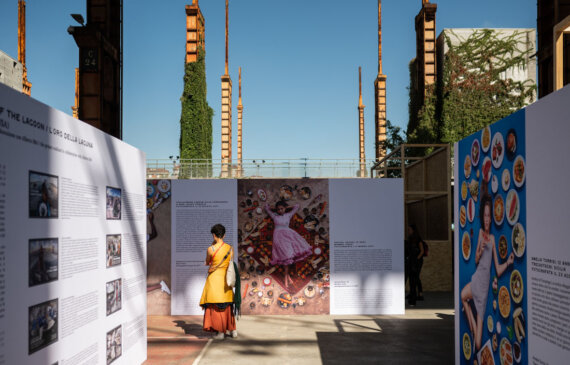 Una donna osserva una esposizione fotografica di un fotografo a Torino, all'interno dell'evento TERRA MADRE