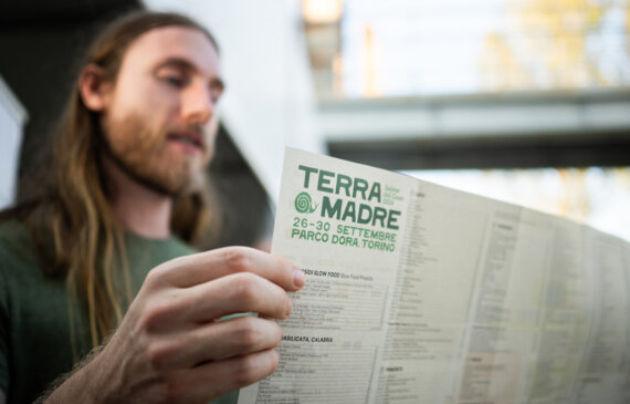 Un ragazzo sfoglia il programma di TERRA MADRE