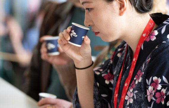 una donna in abiti tradizionali giapponesi annusa una bevanda