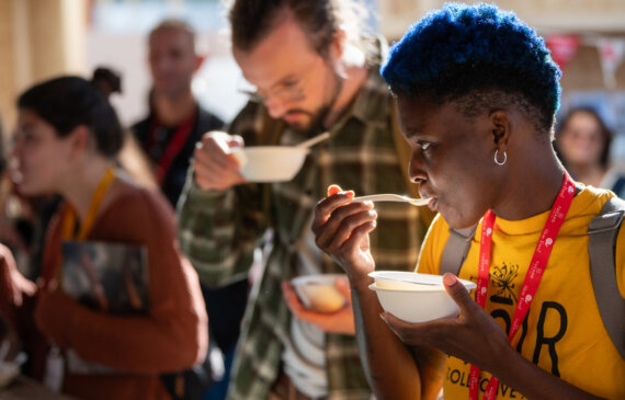 una donna dai capelli blu assaggia una pietanza durante l'evento Terra Madre