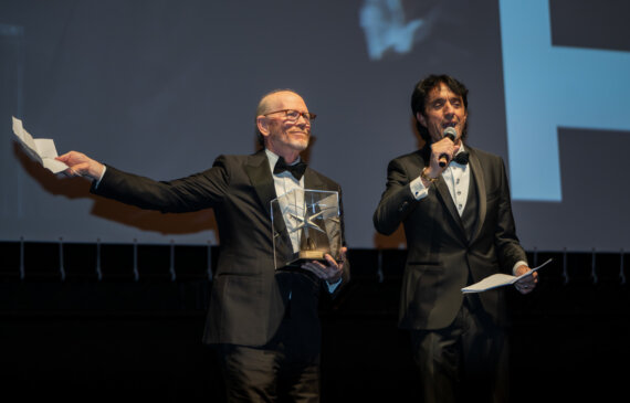 Ron Howard e Giulio Base parlano al microfono durante cerimonia di apertura del Torino Film Festival 2024