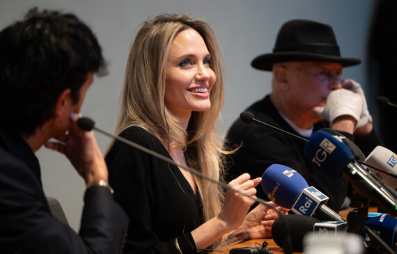 Angelina Jolie sorride mentre parla al microfono durante una conferenza