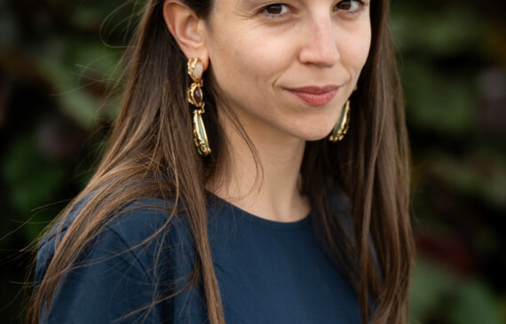 Maria Vittoria Baravelli, curatrice d'arte posa per una fotografia davanti ad una aiuola verde