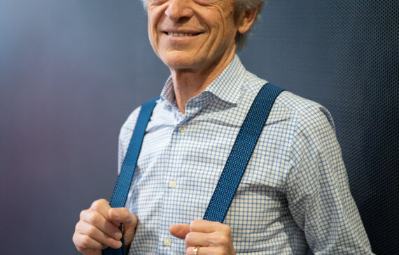 federico rampini posa davanti ad un muro blu davanti al fotografo di ritratti a Torino