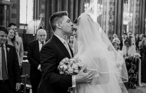 Lo sposo bacia sulla fronte la sposa appena arrivata in chiesa per il loro matrimonio a torino