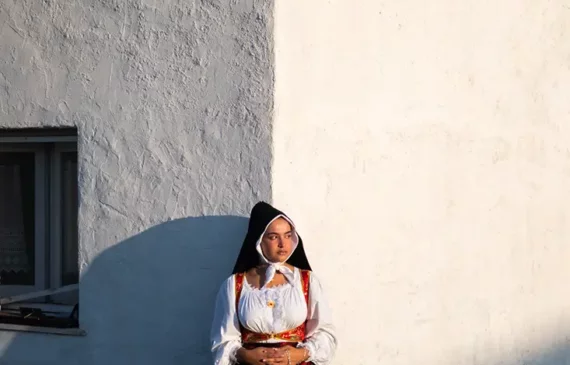 una ragazza posa con un costume tradizionale sardo