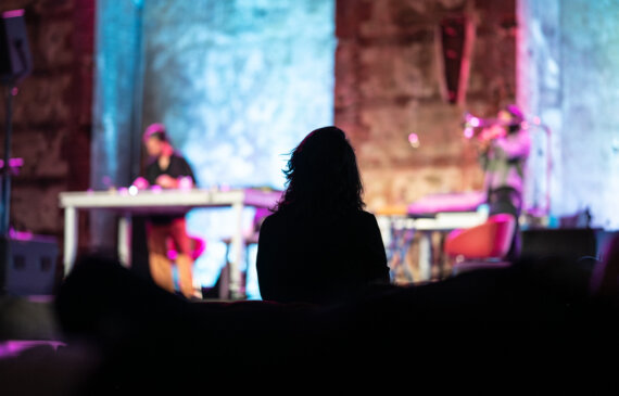 Sagoma in controluce di una donna che ascolta un concerto di musica dal vivo