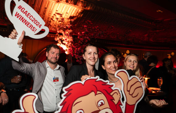 quattro persone sorridono mentre tengono dei cartelli con il logo di generali assicurazioni durante una festa aziendale al Buddha Bar a Montecarlo