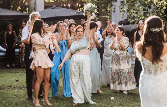 una invitata ad un matrimonio prende il bouquet in aria