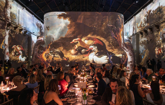 Una cena di gala con proiezioni di dipinti celebri alle pareti